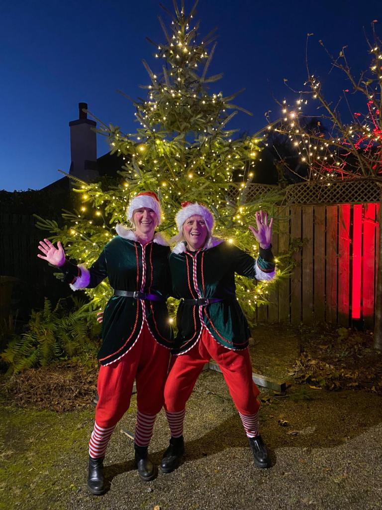 Two dressed as santa helpers